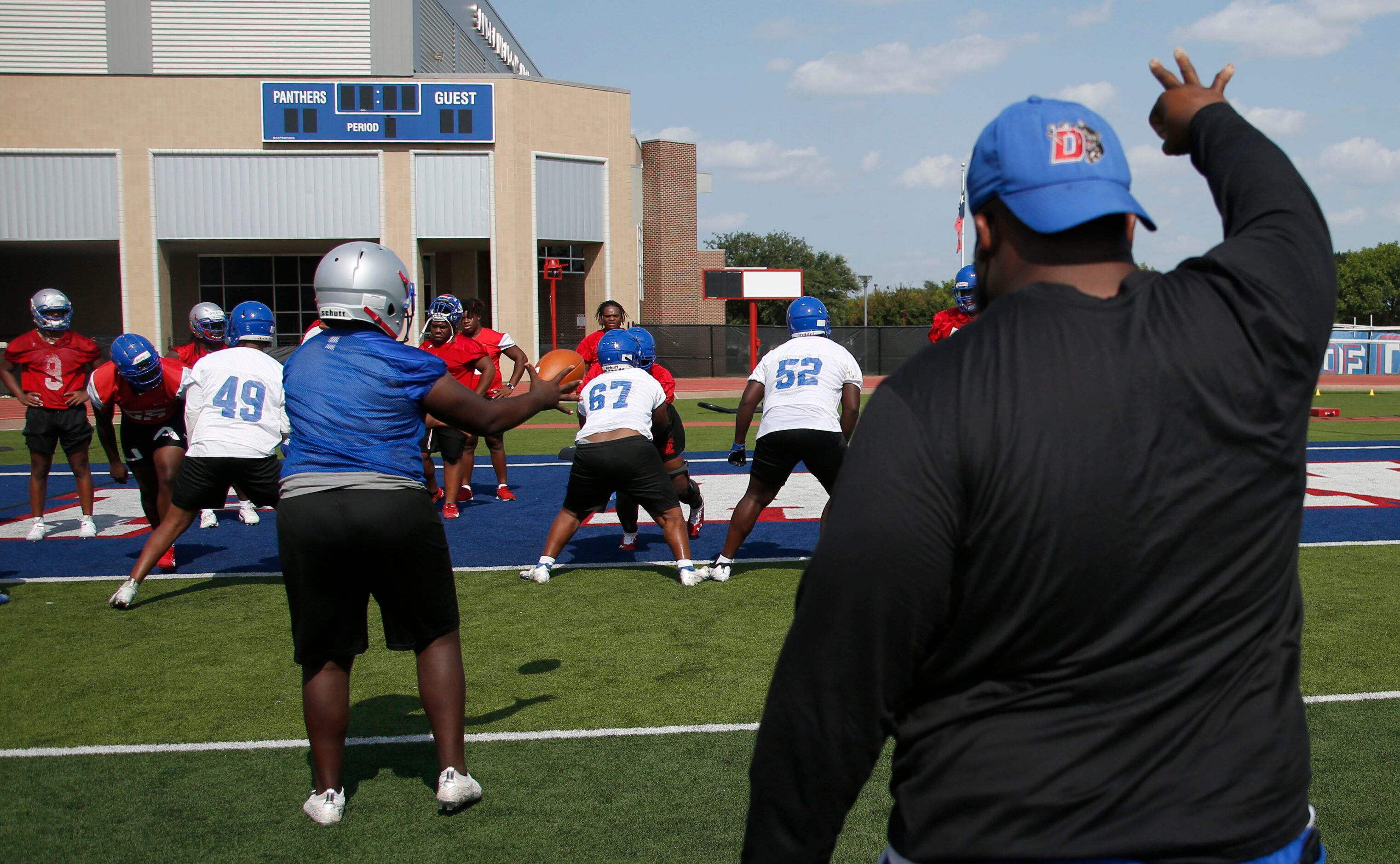 Duncanville Panthers work on a snap drill under the direction of an assistant coach. The...