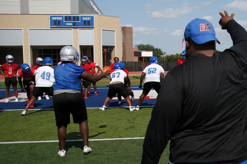 Duncanville Panthers work on a snap drill under the direction of an assistant coach. The...