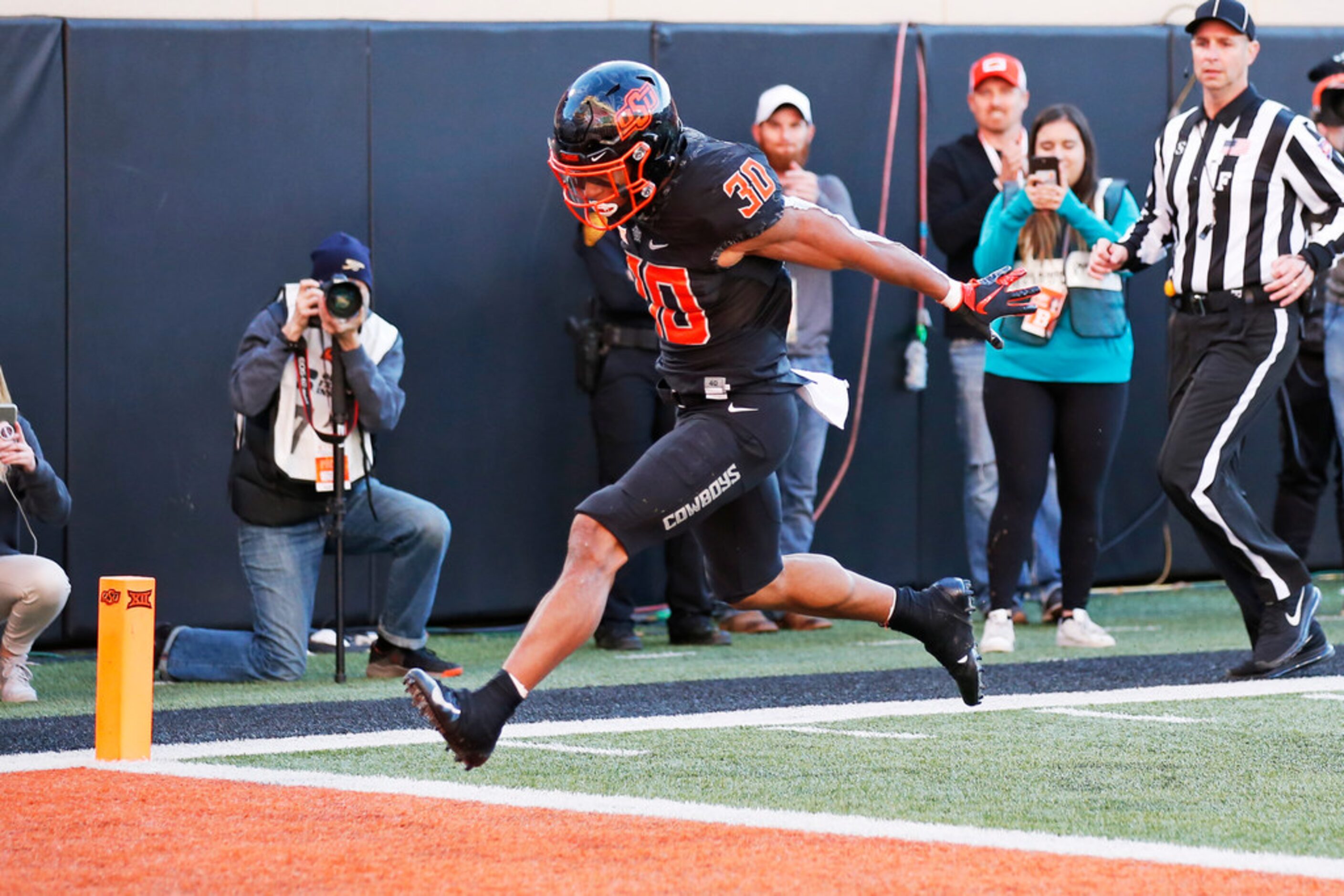 Oklahoma State running back Chuba Hubbard (30) leaps into the end zone with a touchdown in...