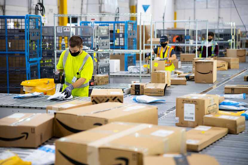 Two Amazon employees sort packages.