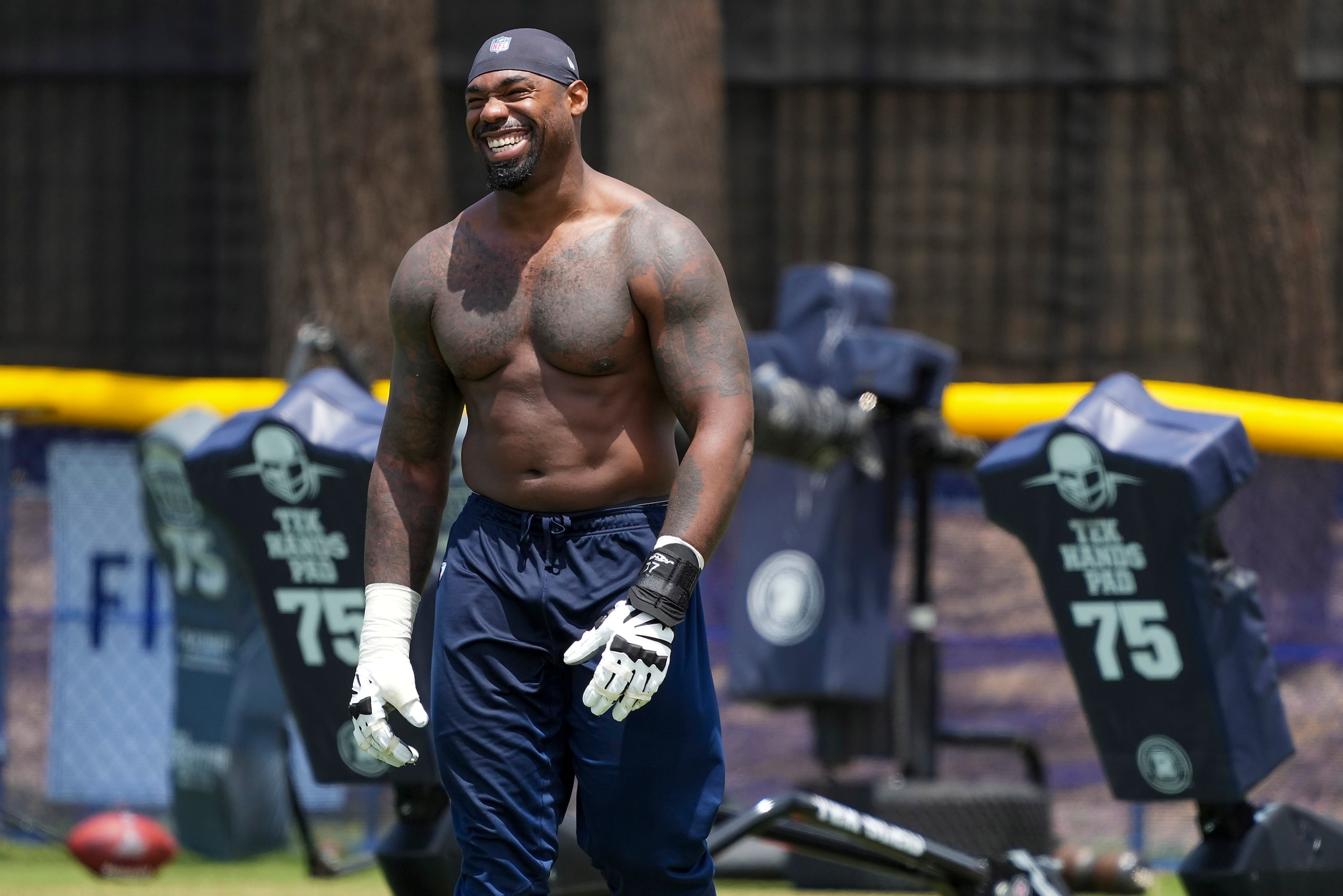 Dallas Cowboys tackle Tyron Smith smiles as he leaves the field following the first practice...