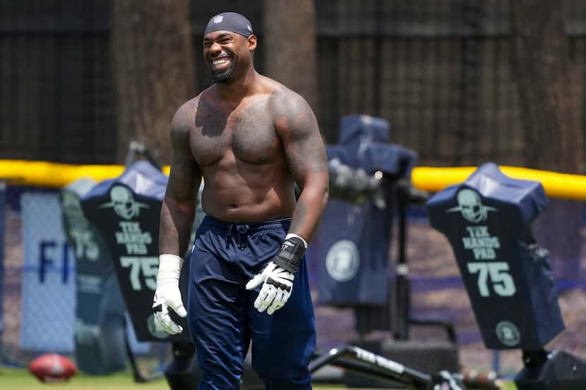 Dallas Cowboys tackle Tyron Smith smiles as he leaves the field following the first practice...