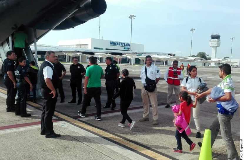 Adultos y niños abordan un avión de la Guardia Nacional de México al ser deportados a Honduras.