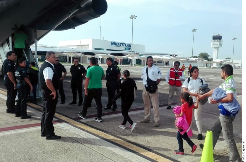 Adultos y niños abordan un avión de la Guardia Nacional de México al ser deportados a Honduras.