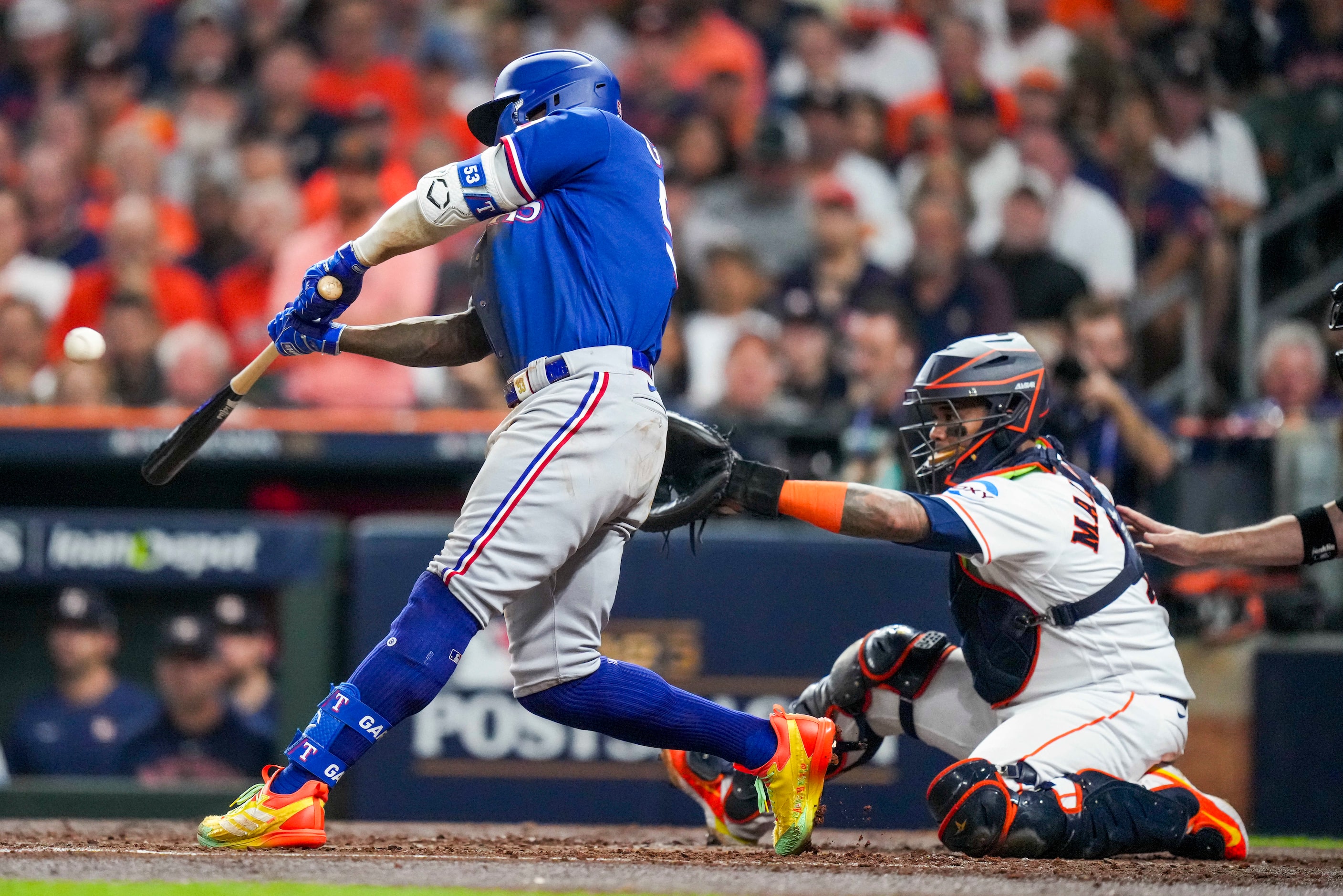 Texas Rangers right fielder Adolis Garcia hits a home run in front of Houston Astros catcher...