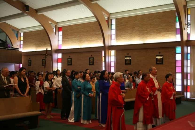 
The congregation stands for the recessional at St. Peter Vietnamese Church after the Mass...