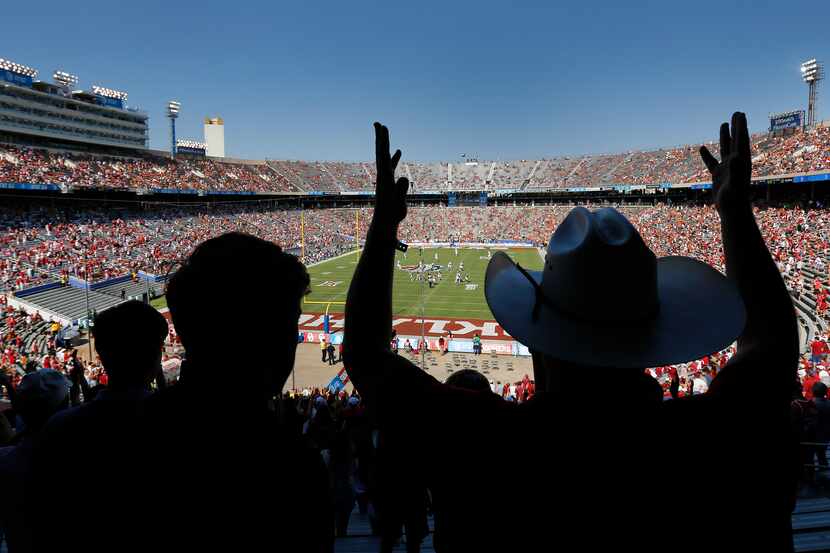 University of Oklahoma student Beau Baggett (right) forms the letters OU as the crowd cheers...