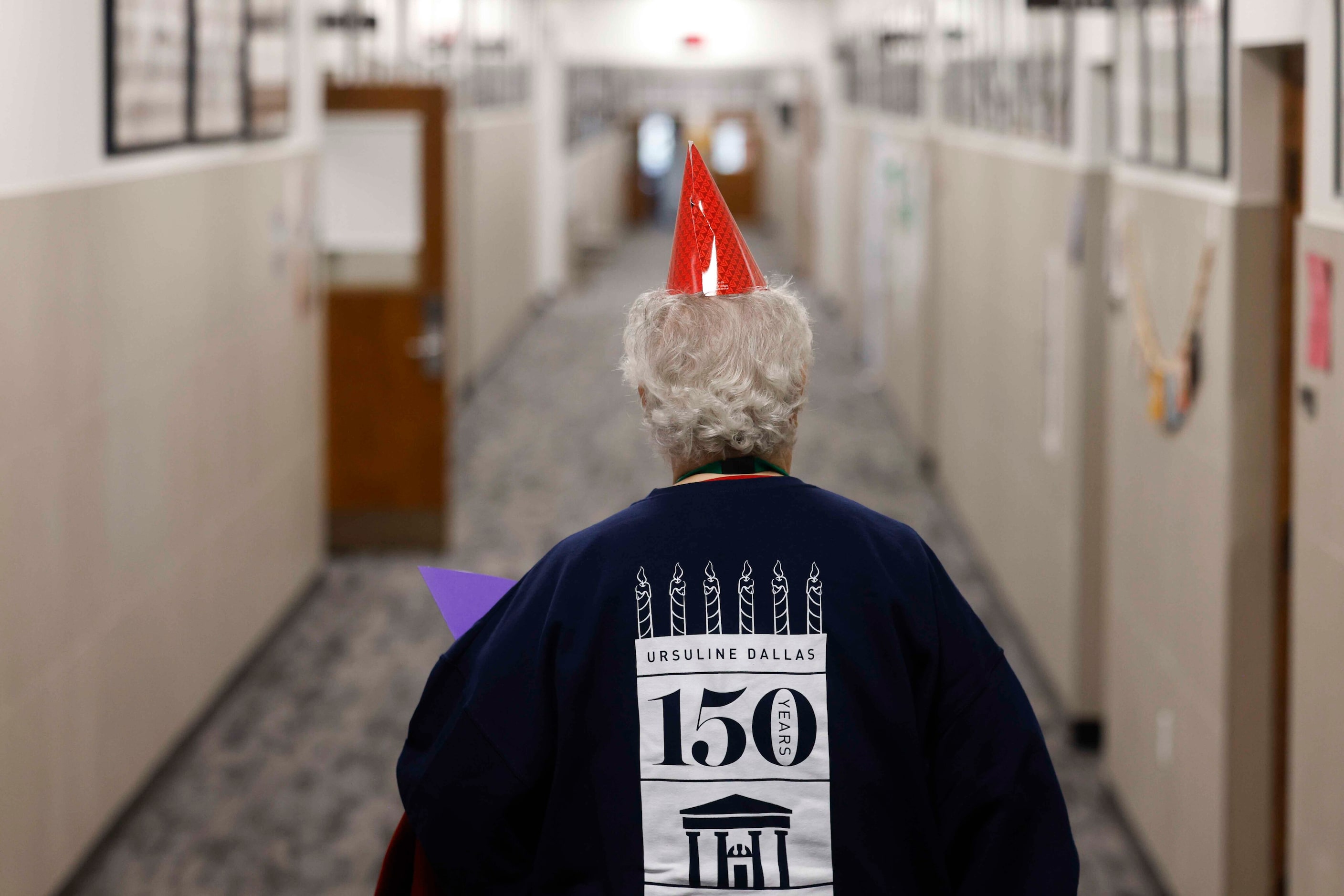 Sister Lois Castillon walks down the hallway wearing Ursaline Dallas hoodie and birthday...