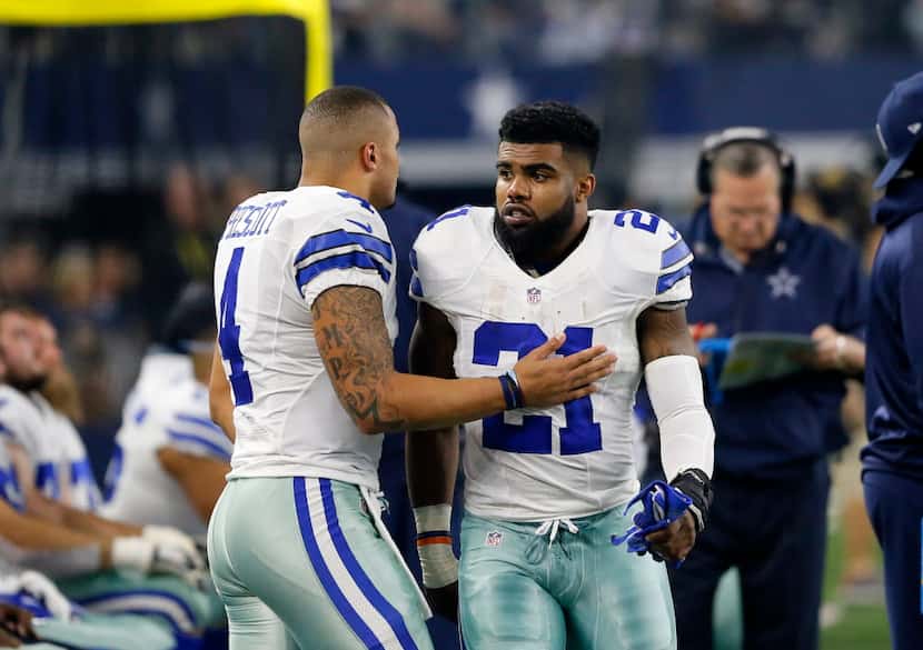 Dallas Cowboys' Dak Prescott (left) and Ezekiel Elliott (21) talk on the sideline during an...