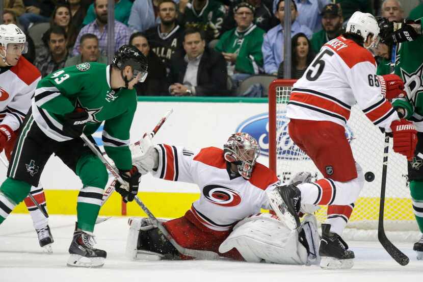 The puck gets past Carolina Hurricanes goalie Cam Ward (30), defenders Victor Rask (49) and...