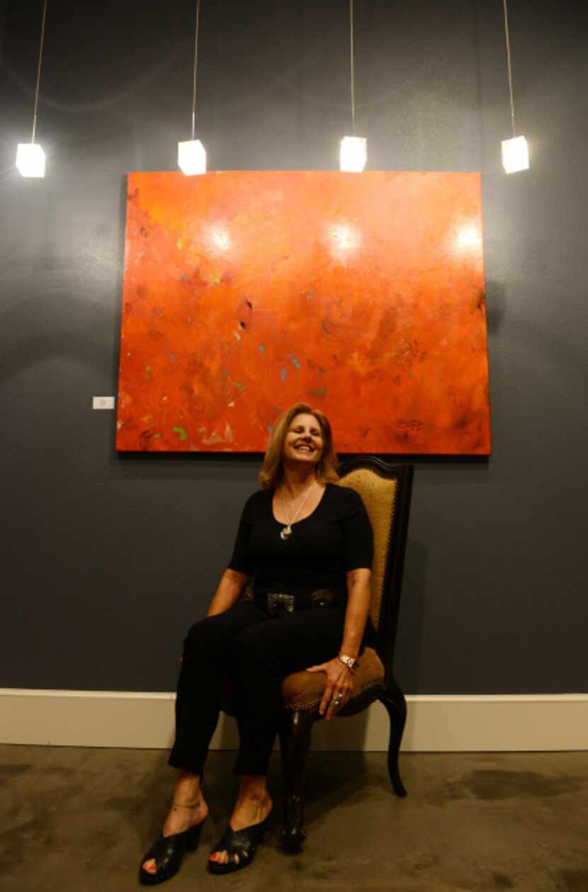 Susan Bishop sits next to her piece "Chili Hot Red." Bishop, a local artist and planning...