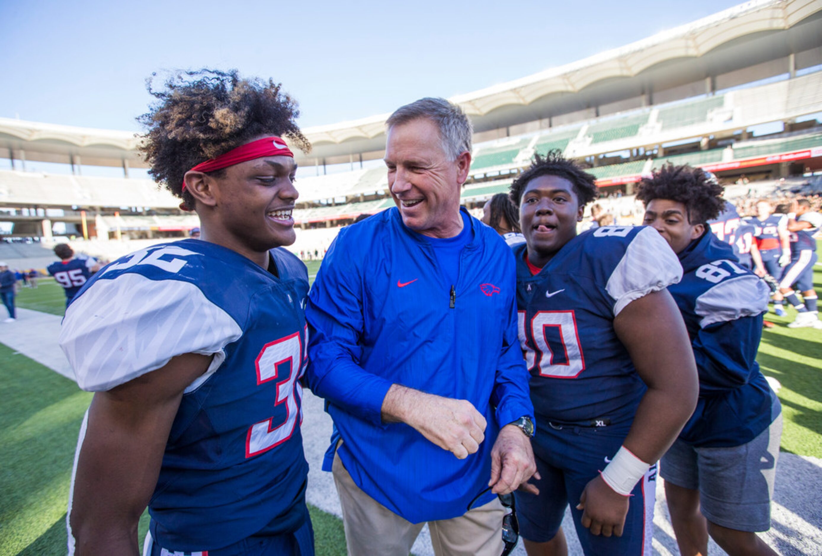 Allen head coach Terry Gambill, center, celebrates with defensive back Zayteak McGhee (32)...