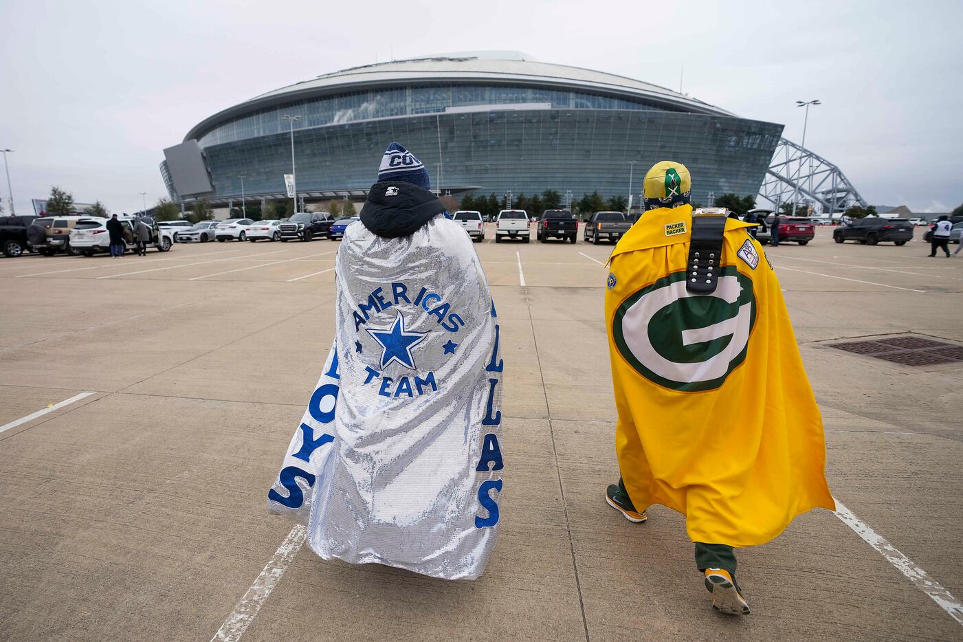 Dallas Cowboys fan Enrique Doster and Green Bay Packers fan David Gallegos head to the...