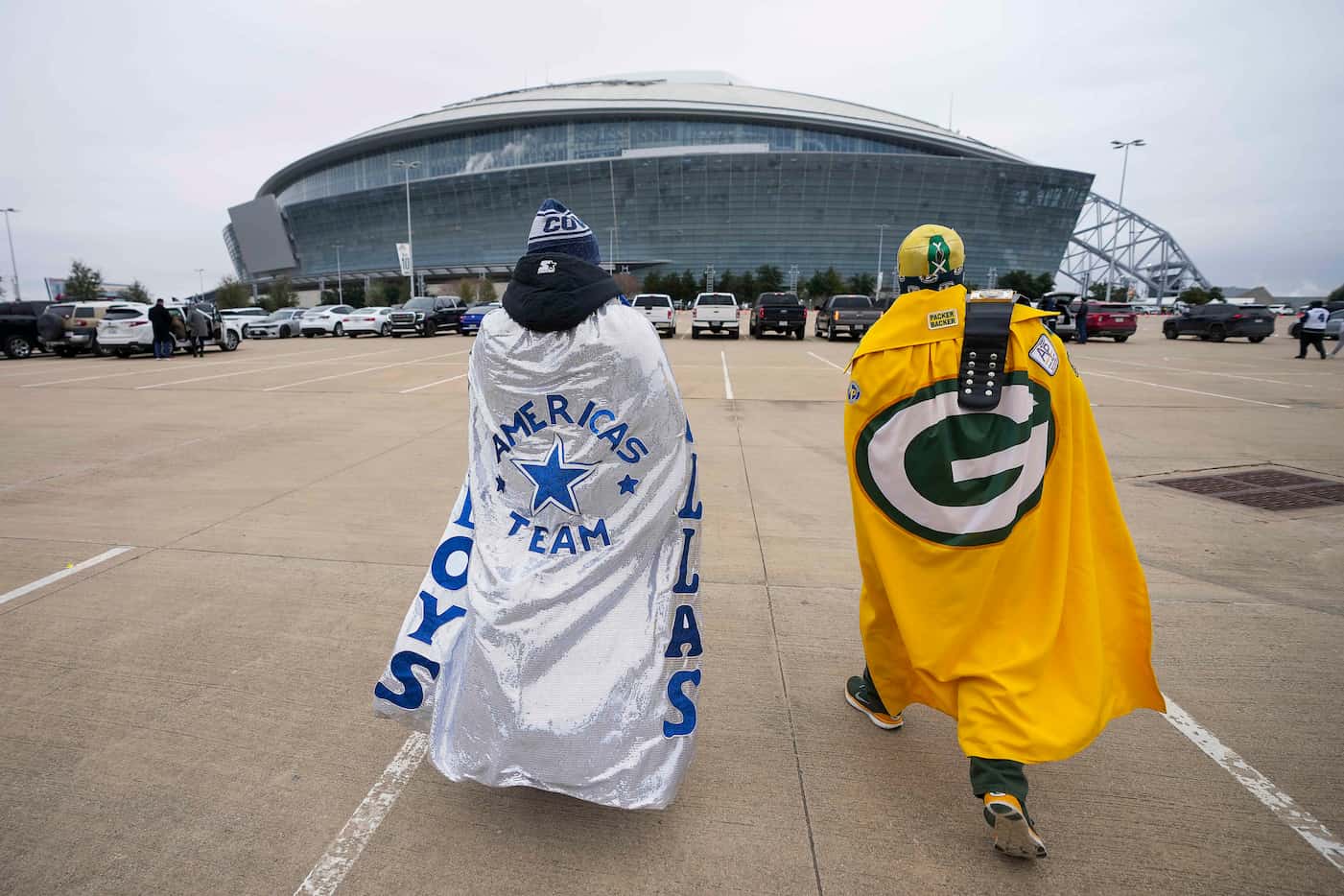 Dallas Cowboys fan Enrique Doster and Green Bay Packers fan David Gallegos head to the...
