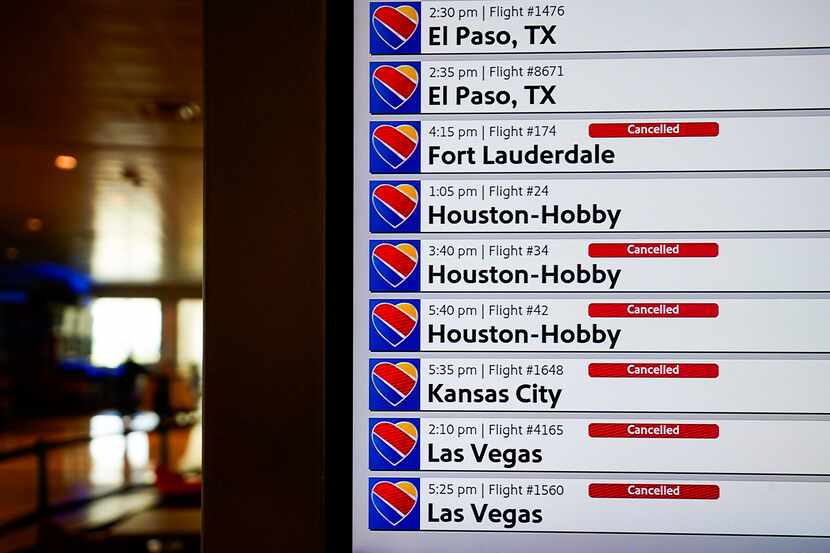 Flight status boards show cancelled Southwest Airlines flights at Dallas Love Field on...
