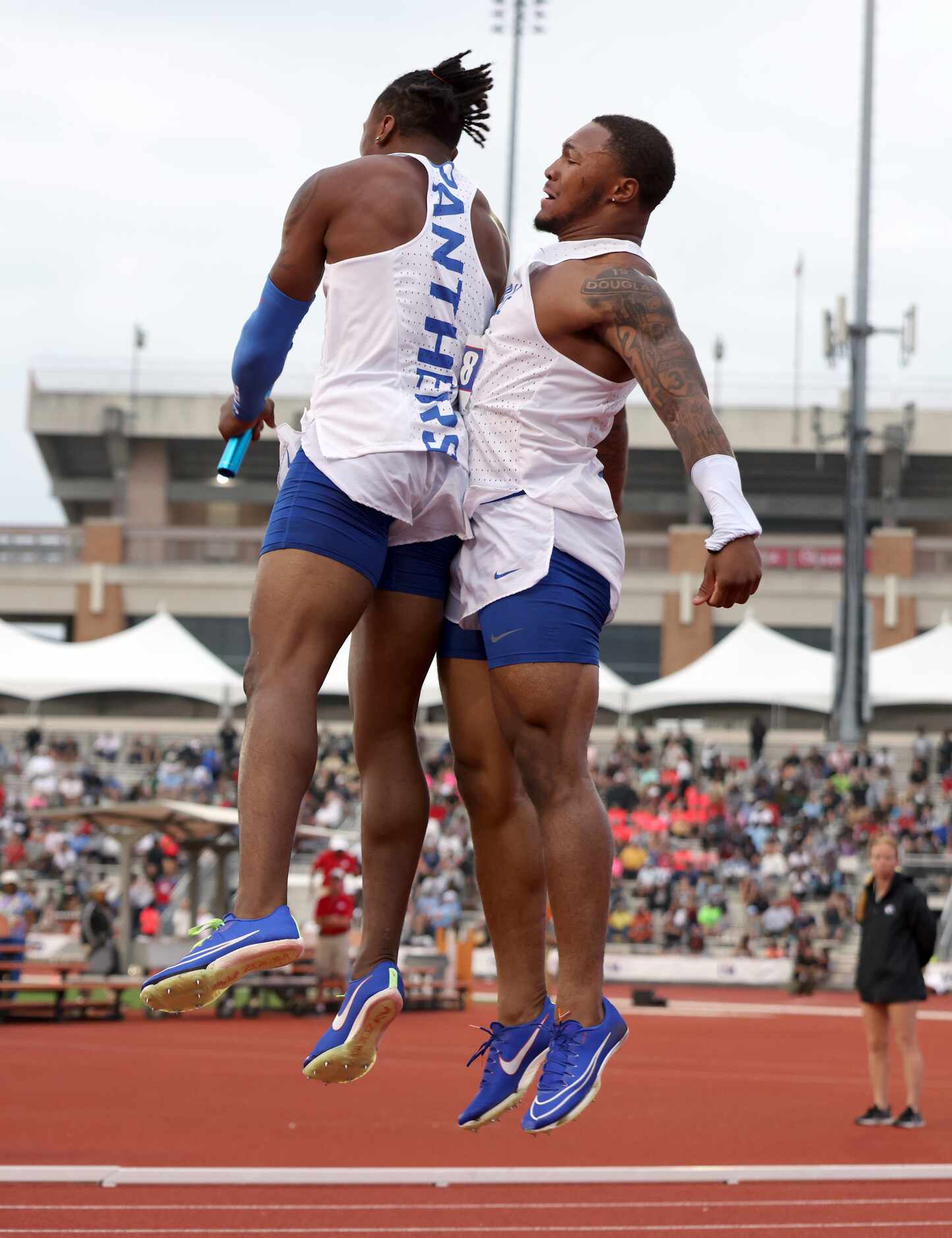 Duncanville sprinters Dakorien Moore, left, and Caden Durham take to the air with their...