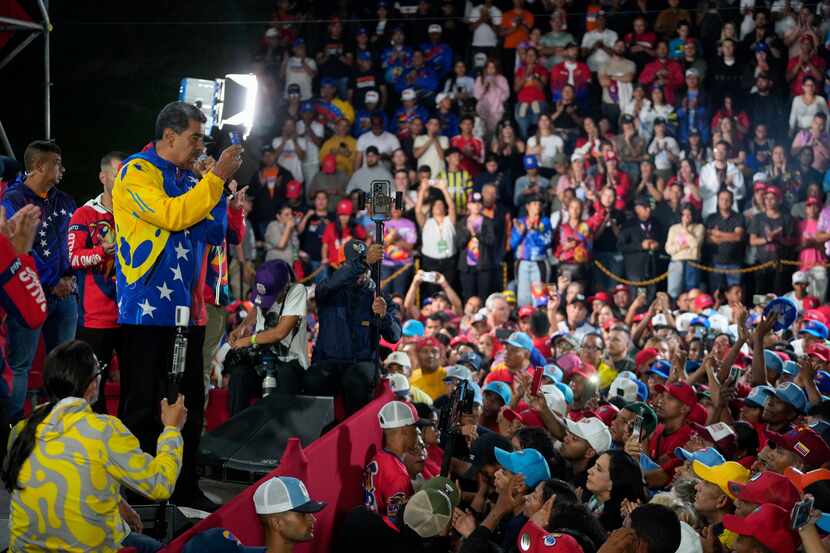 President Nicolas Maduro addresses supporters gathered outside the Miraflores presidential...