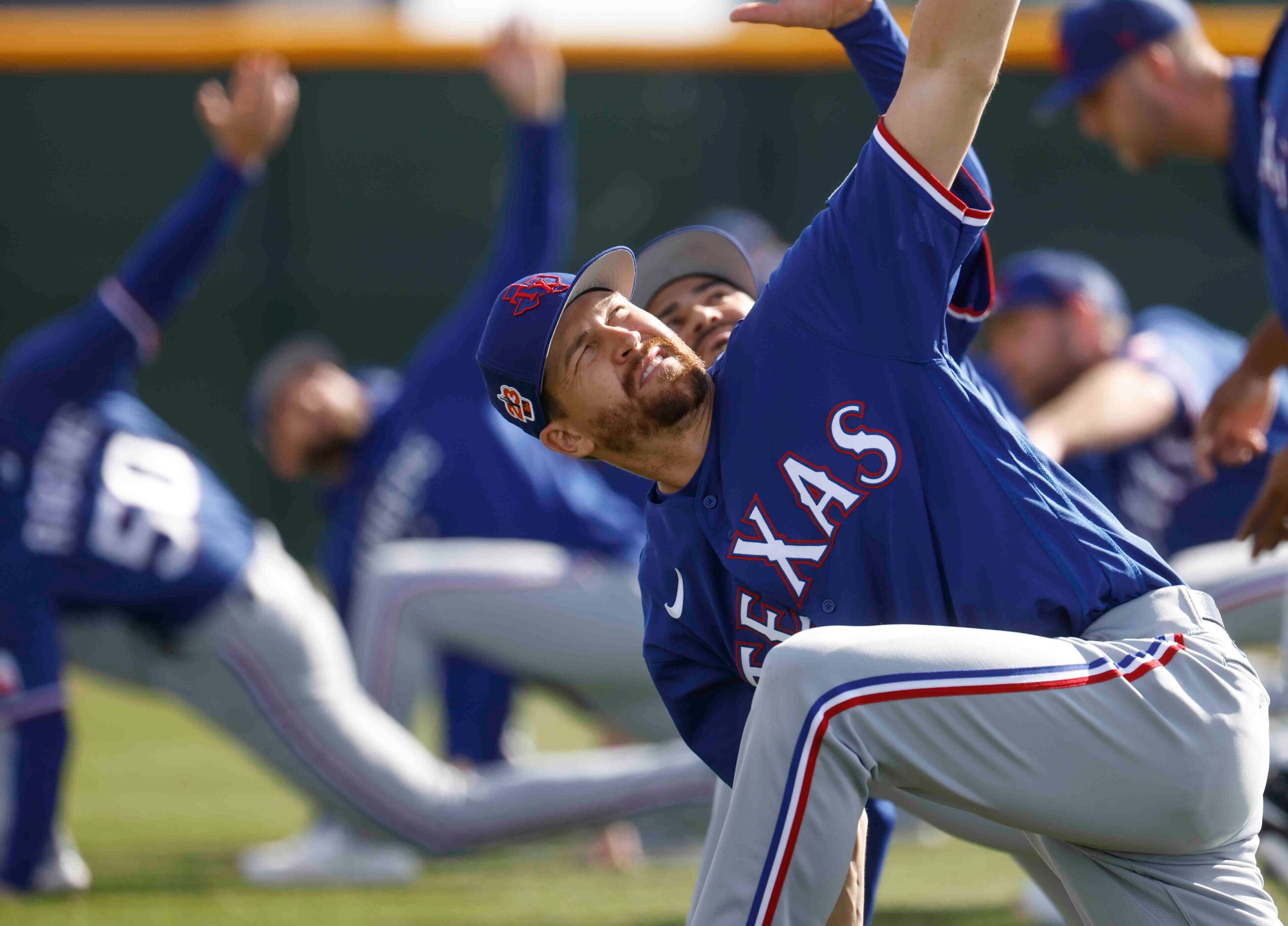 Texas Rangers pitcher Jacob deGrom stretches during a spring training workout at the team's...