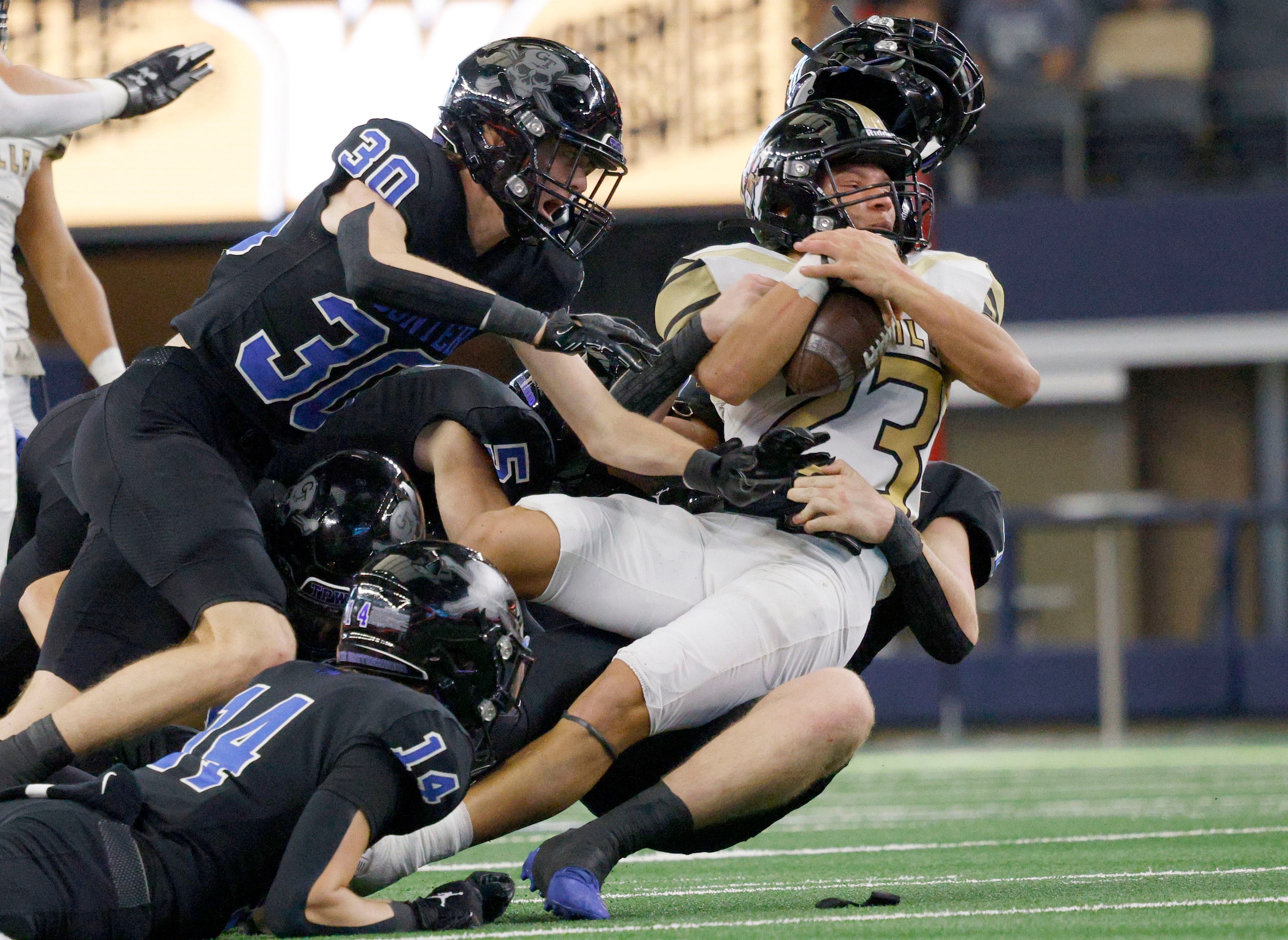 Woodville's Marquis Menefee (23) is tackled by Gunter’s players in the first half of the...