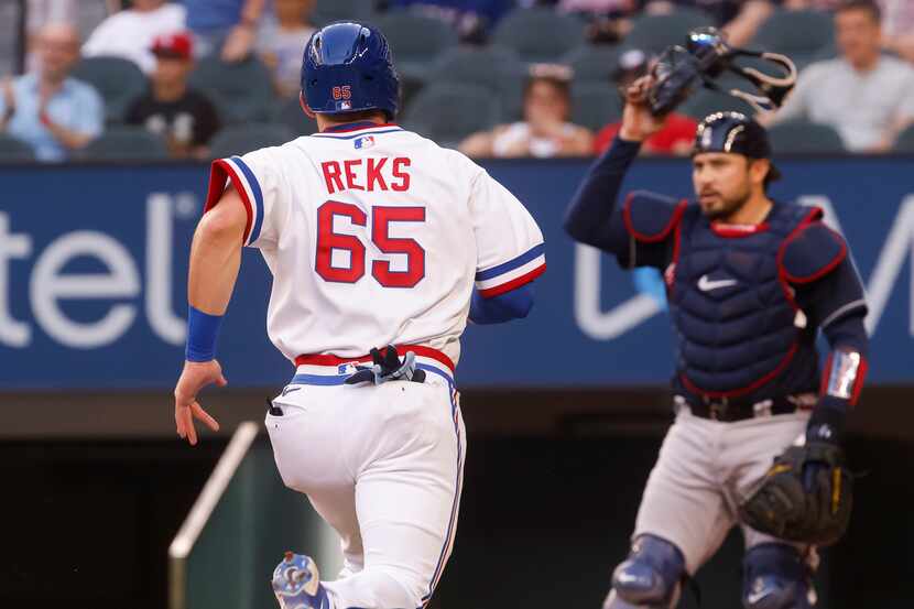 Texas Rangers Left fielder Zach Reks (65) scores off a hit by Texas Rangers catcher Sam Huff...