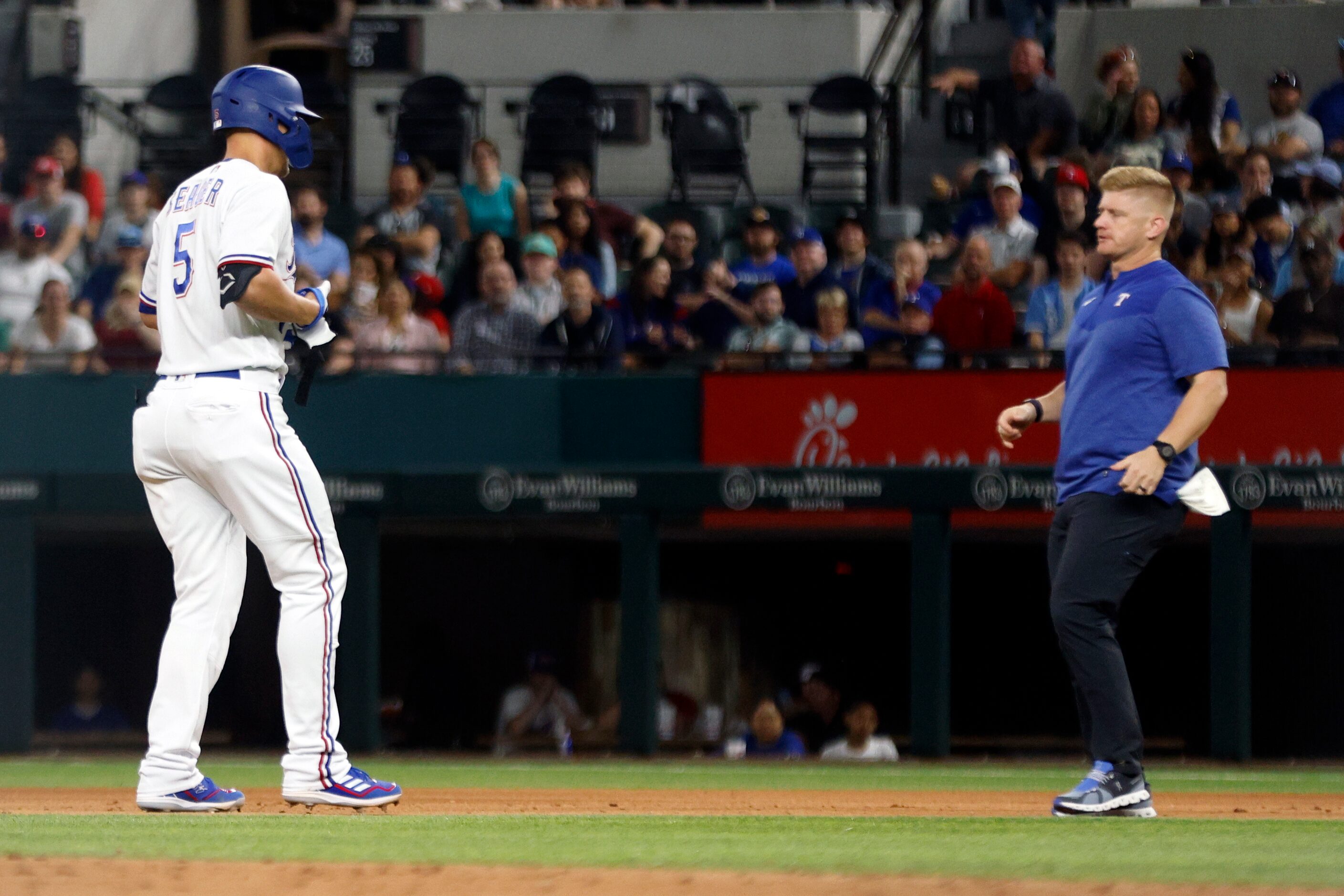 Texas Rangers shortstop Corey Seager (5) limps to the dugout and is greeted by a member of...