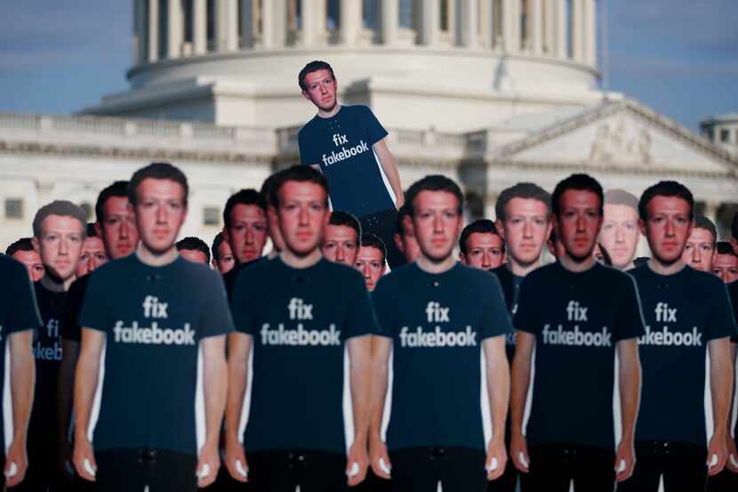 Life-sized cutouts of Facebook CEO Mark Zuckerberg wearing 'Fix Fakebook' t-shirts are...