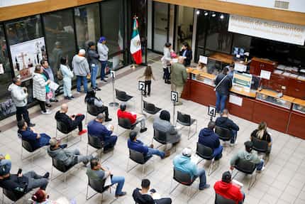 La gente espera que se revisen sus documentos de pasaporte en el Consulado General de México...