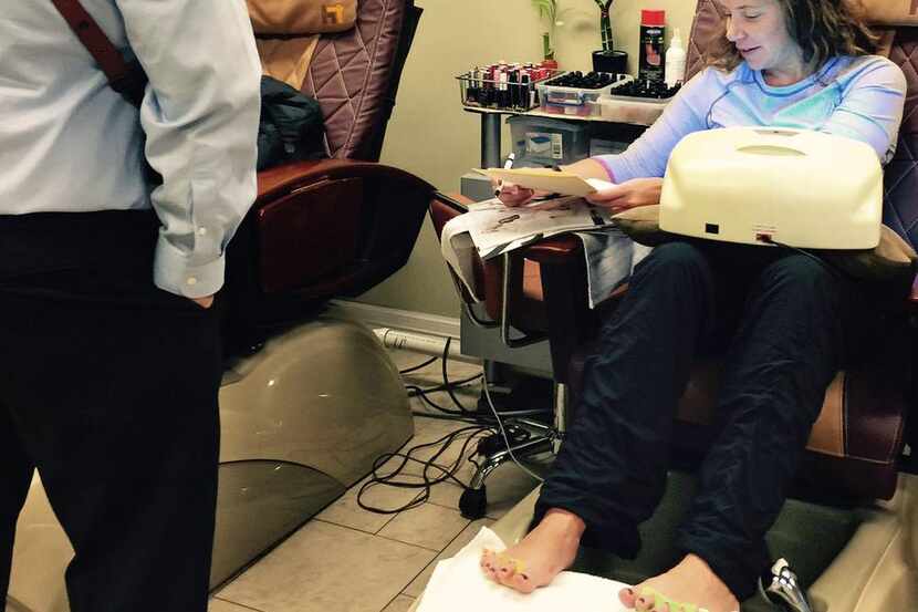 State District Judge Jennifer Bennett  signs a warrant while getting her nails done. She...