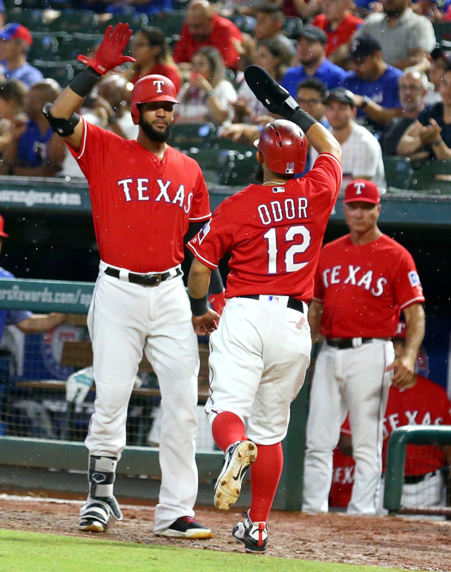 Texas Rangers' Nomar Mazara, left, greets Rougned Odor (12) who scored during the first...