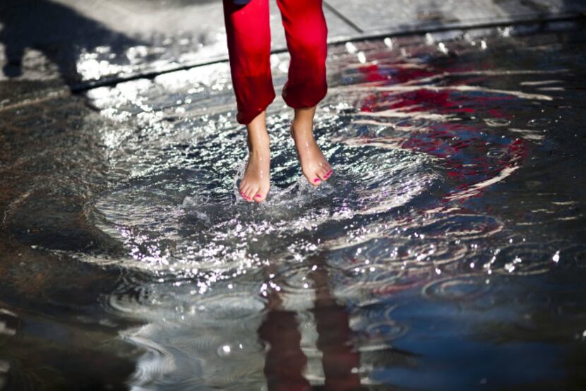 Madeline Glass, 6, splashes around in a wading pool in the children's area of Klyde Warren...