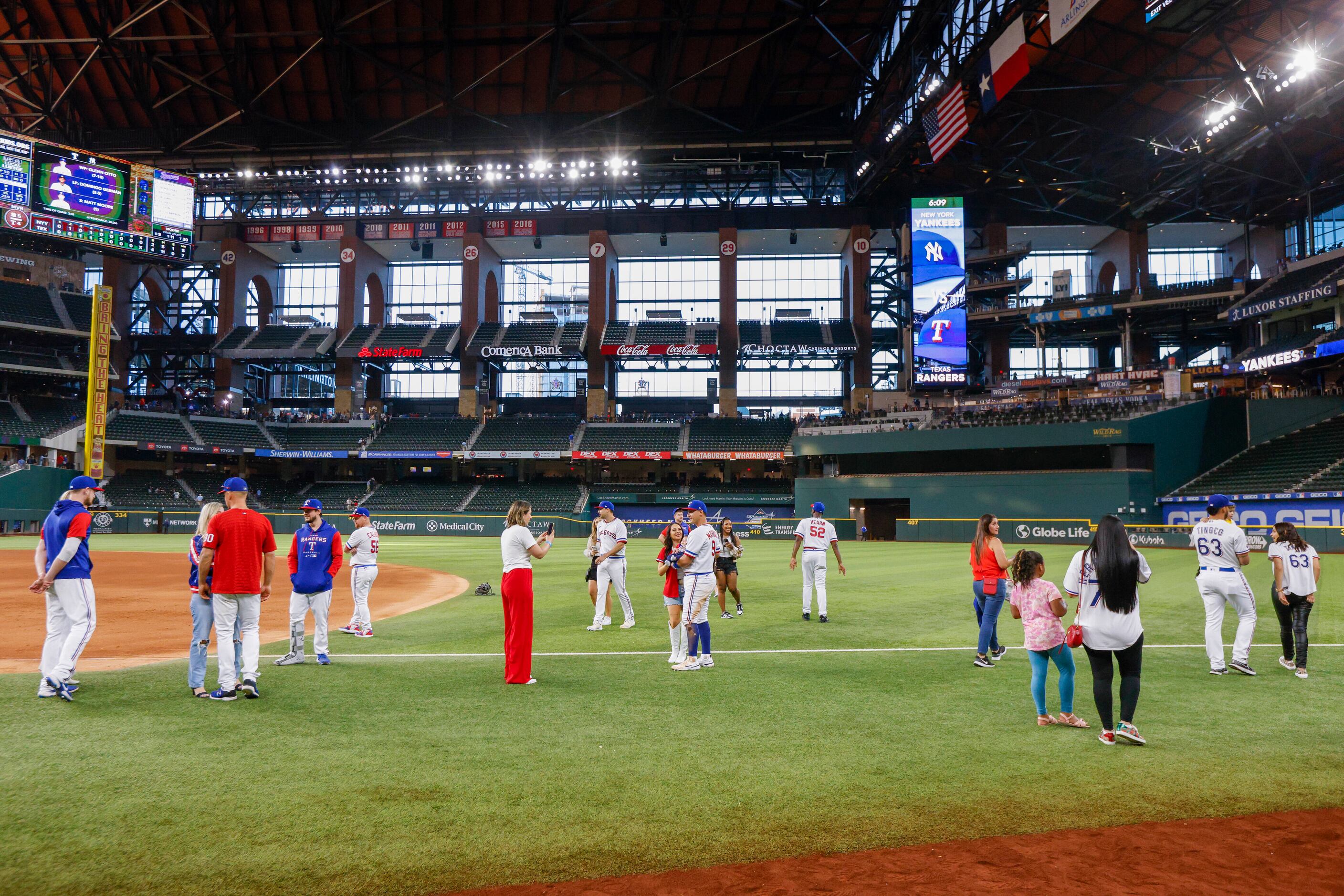 Texas Rangers players take photos with friends and family members after the final game of...