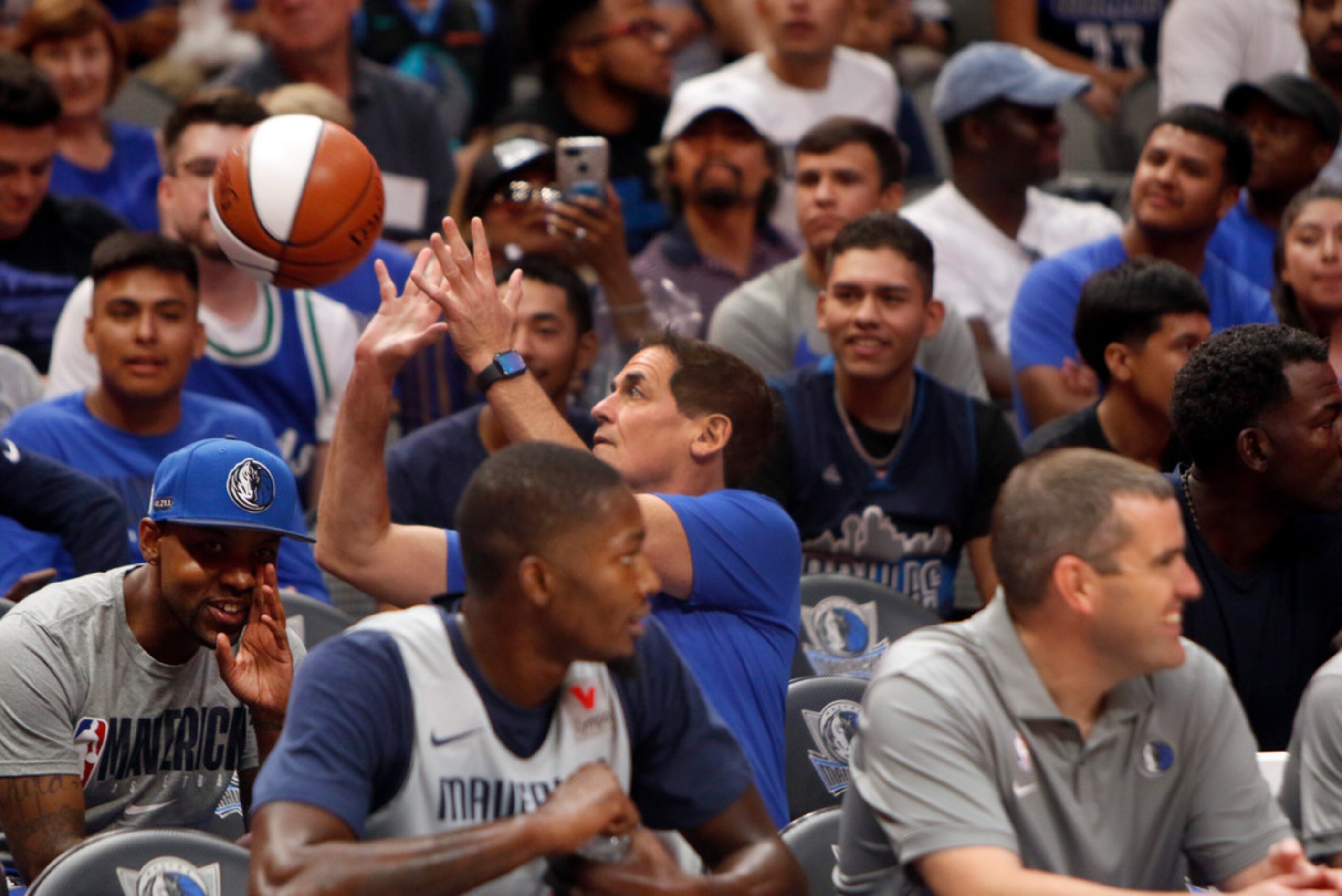 Dallas Mavericks owner Mark Cuban gets off a shot as he scored with a fan by honoring their...