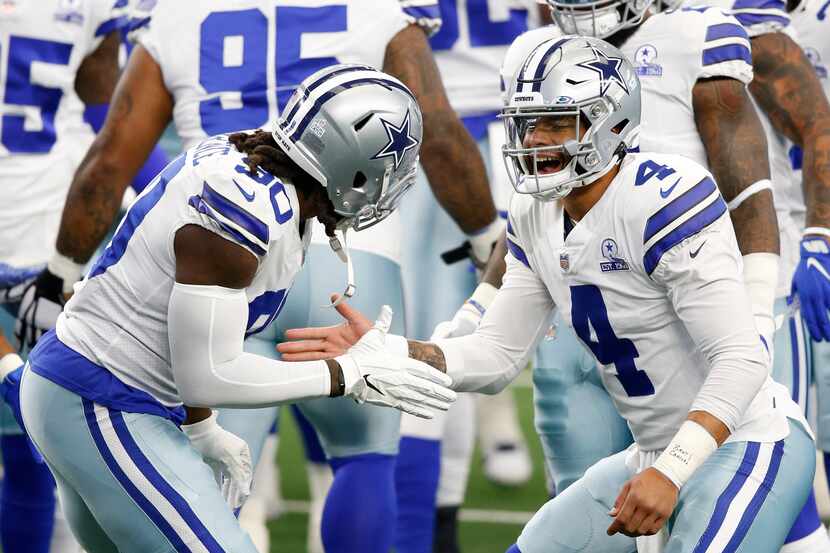 Dallas Cowboys quarterback Dak Prescott (4) greets Dallas Cowboys defensive end DeMarcus...