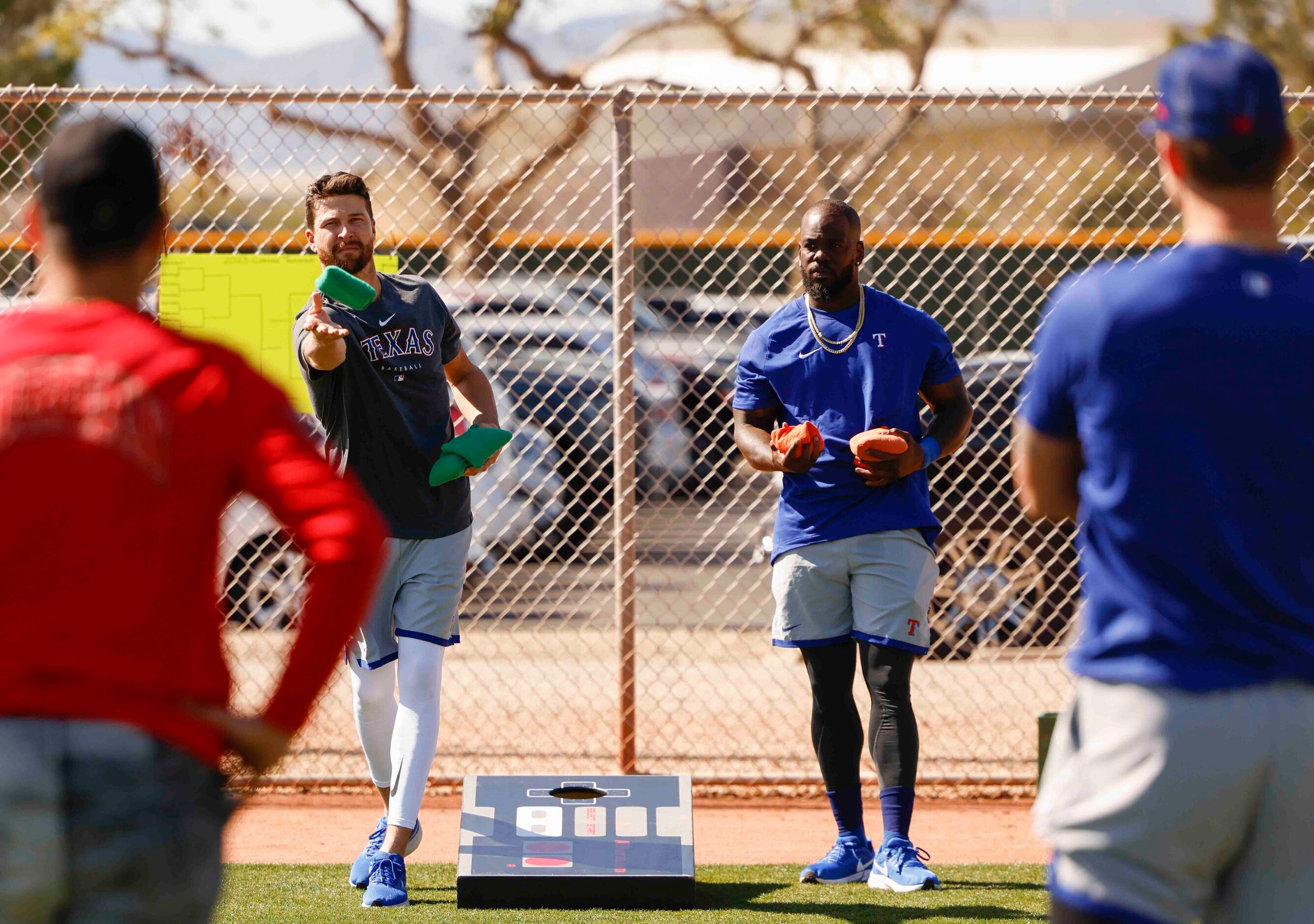 Texas Rangers pitcher Jacob deGrom, left, and outfielder Adolis Garcia play cornhole...