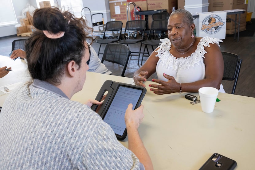 Volunteer James Perkins (left) asks resident Chenequa Boykin public health survey questions...