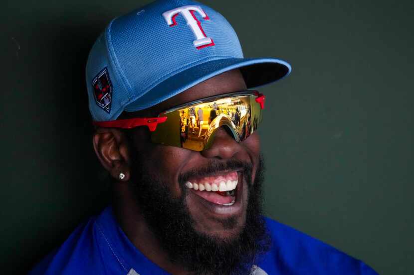Texas Rangers outfielder Adolis García laughs in the dugout during the first inning of a...