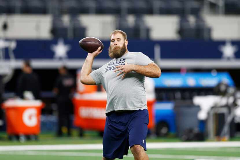 Dallas Cowboys center Travis Frederick throws during warm-ups before an NFL football game...