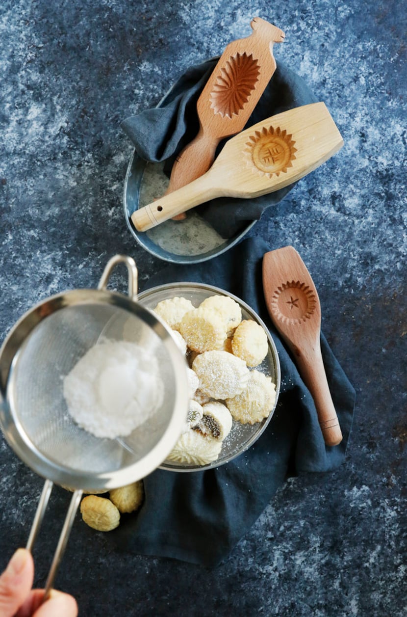 
Kristen Massad sprinkles powdered sugar on top of ma'amoul cookies.