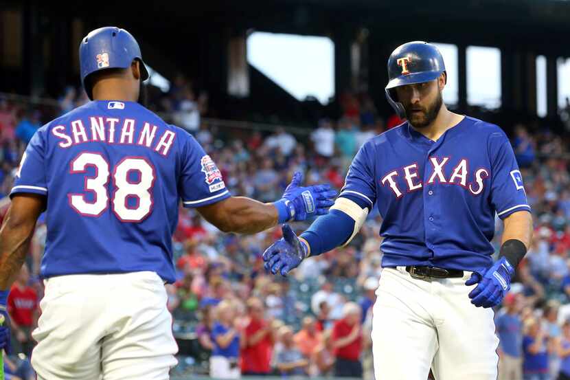Texas Rangers' Danny Santana (38) celebrates the solo home run by Joey Gallo (13) during the...