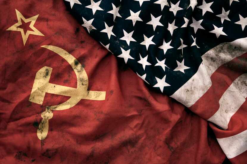 Low key photography of grungy old Soviet Union and United States of America flags. USSR,...