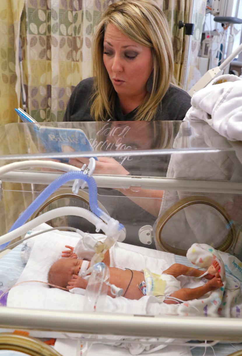 Anna Aguilar reads a book to her son, Cannon Aguilar, at the neonatal intensive care unit at...