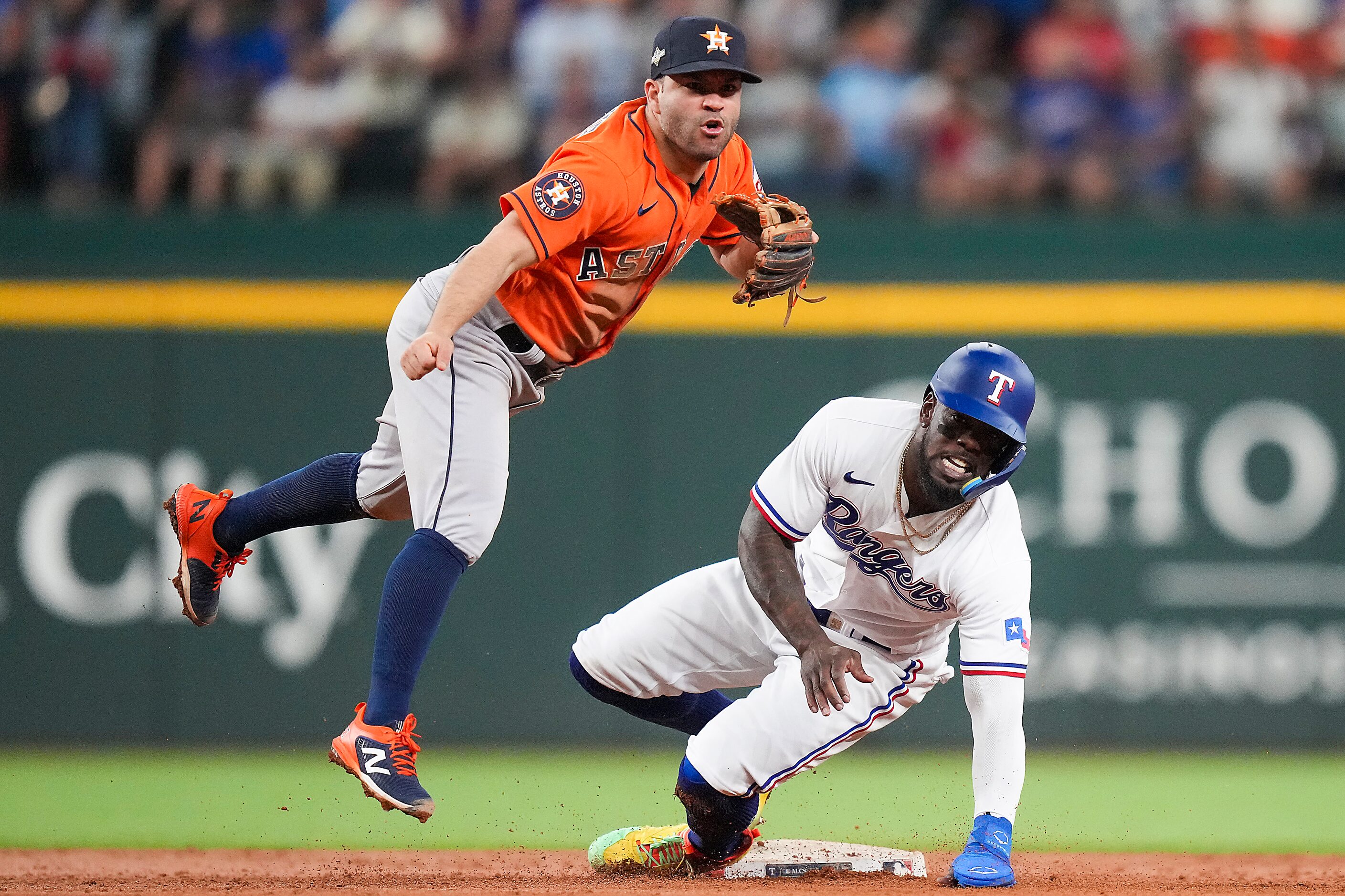 Houston Astros second baseman Jose Altuve turns a double play over Texas Rangers right...