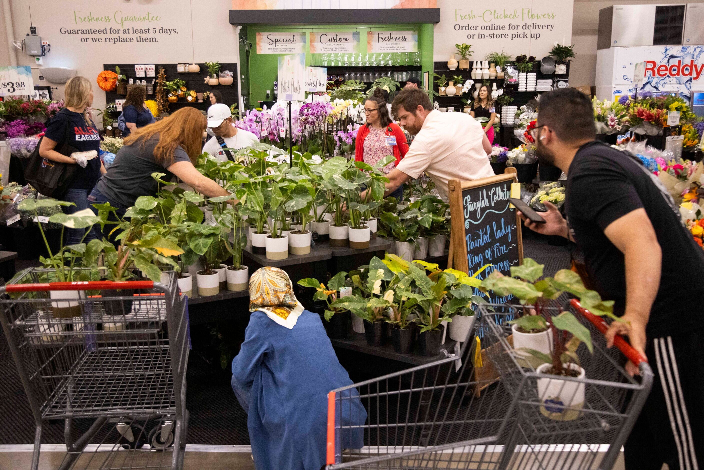 Customers shop the floral section during the grand opening of the H-E-B store in Allen on...