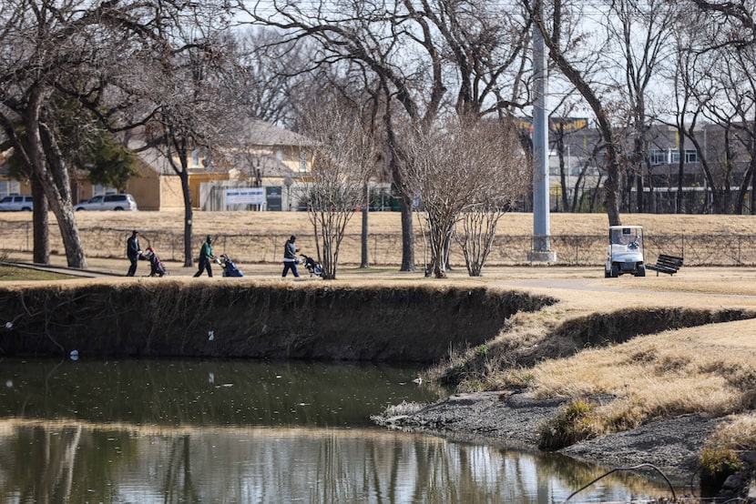 Golfers walk near an eroded section of Tenison Glen Golf Course in Dallas.