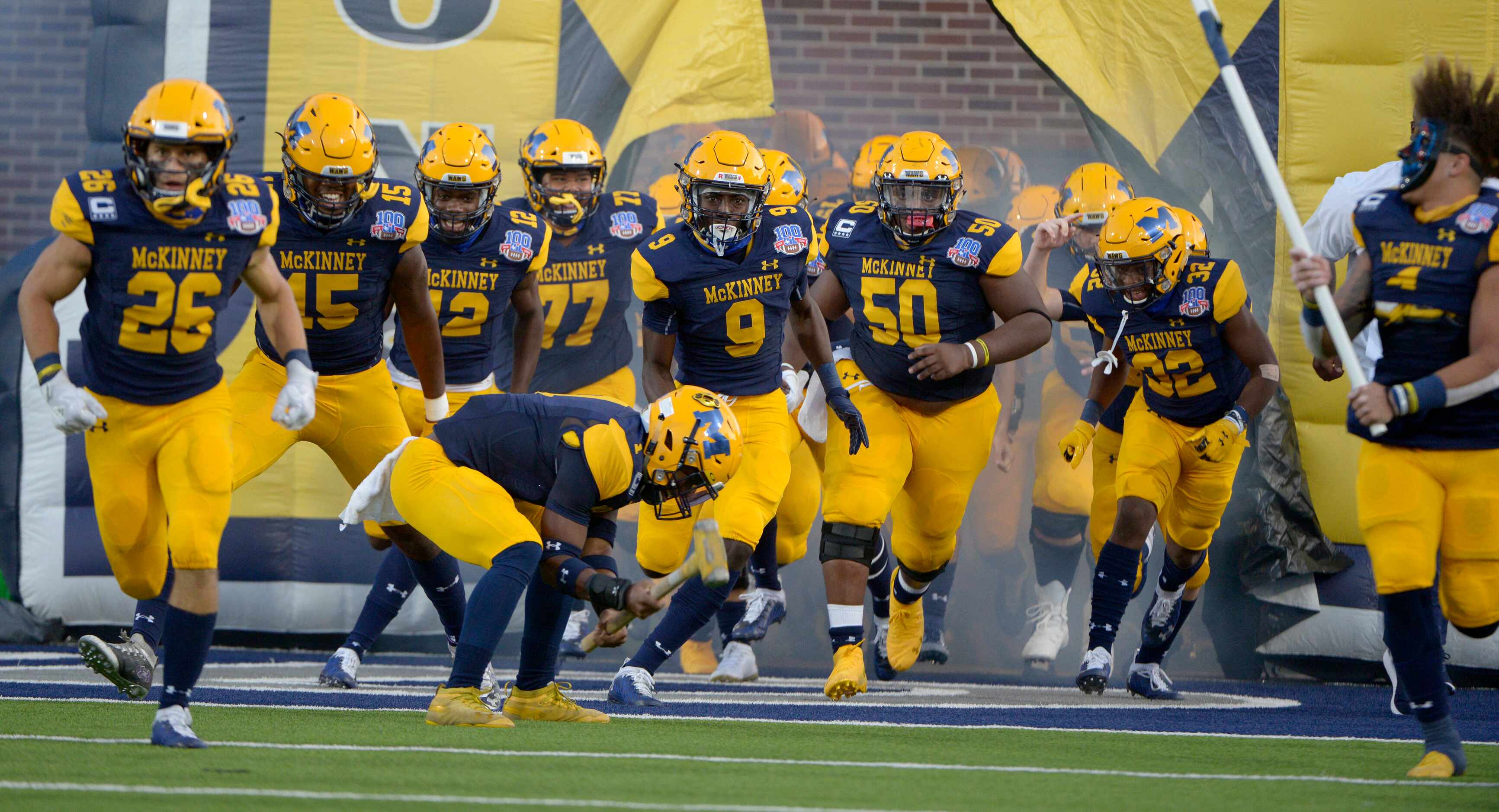 McKinney players run onto the field before a high school football game between Plano and...