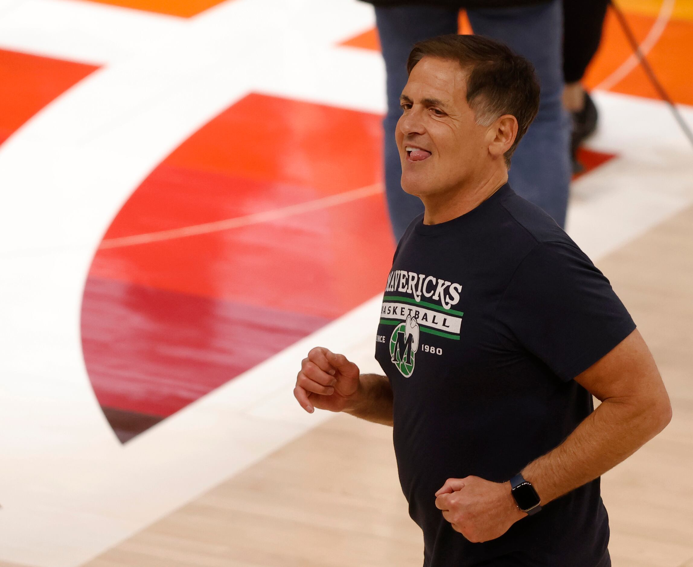 Dallas Mavericks owner Mark Cuban smiles as he makes his way across the court after game 6...