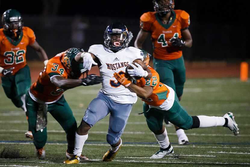 Sachse running back Myles Nash (3) is brought down by Naaman Forest's Adrian Brown (34) and...