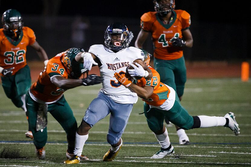 Sachse running back Myles Nash (3) is brought down by Naaman Forest's Adrian Brown (34) and...