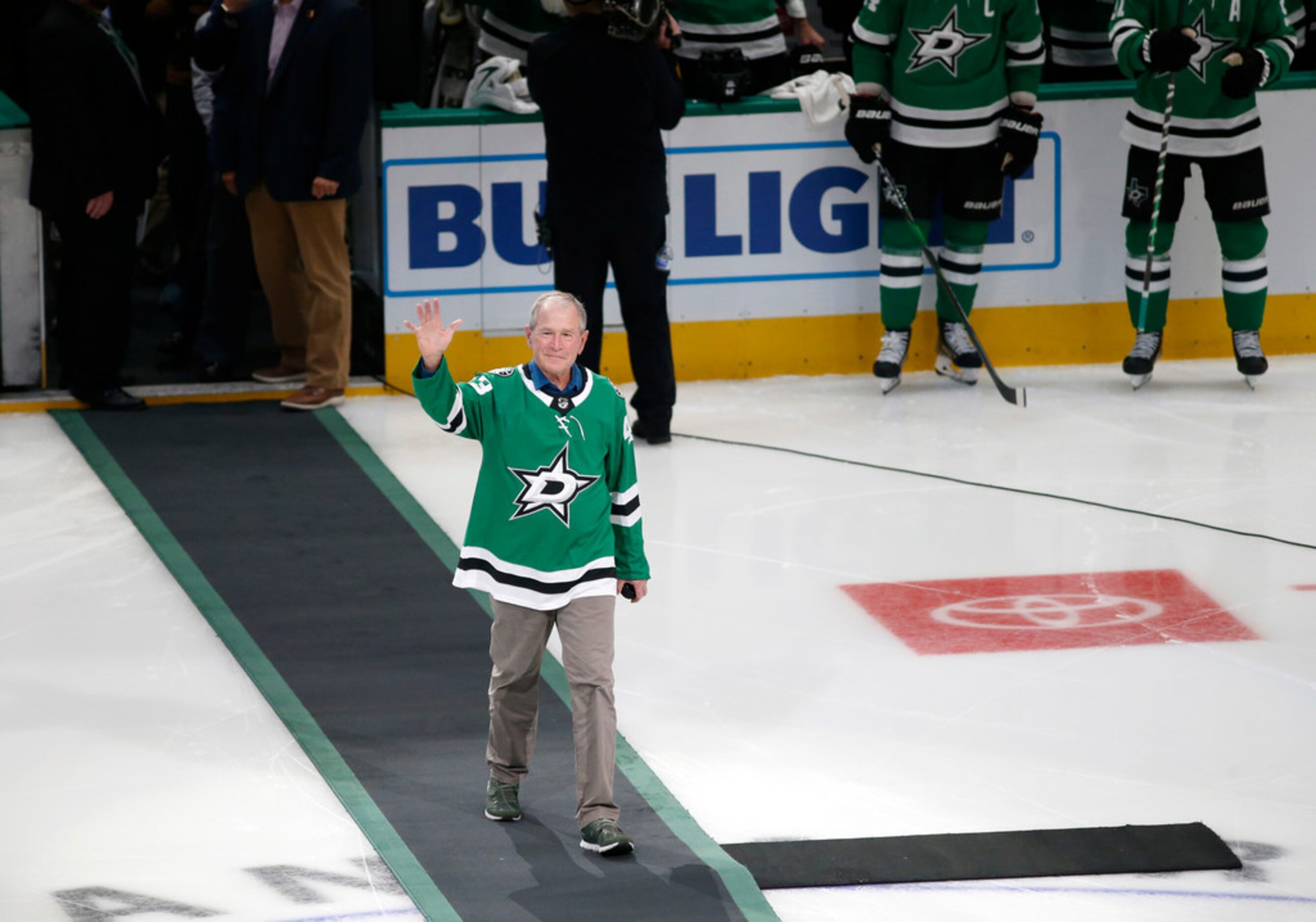 Former President George W. Bush waves to the fans before dropping the puck before a game...