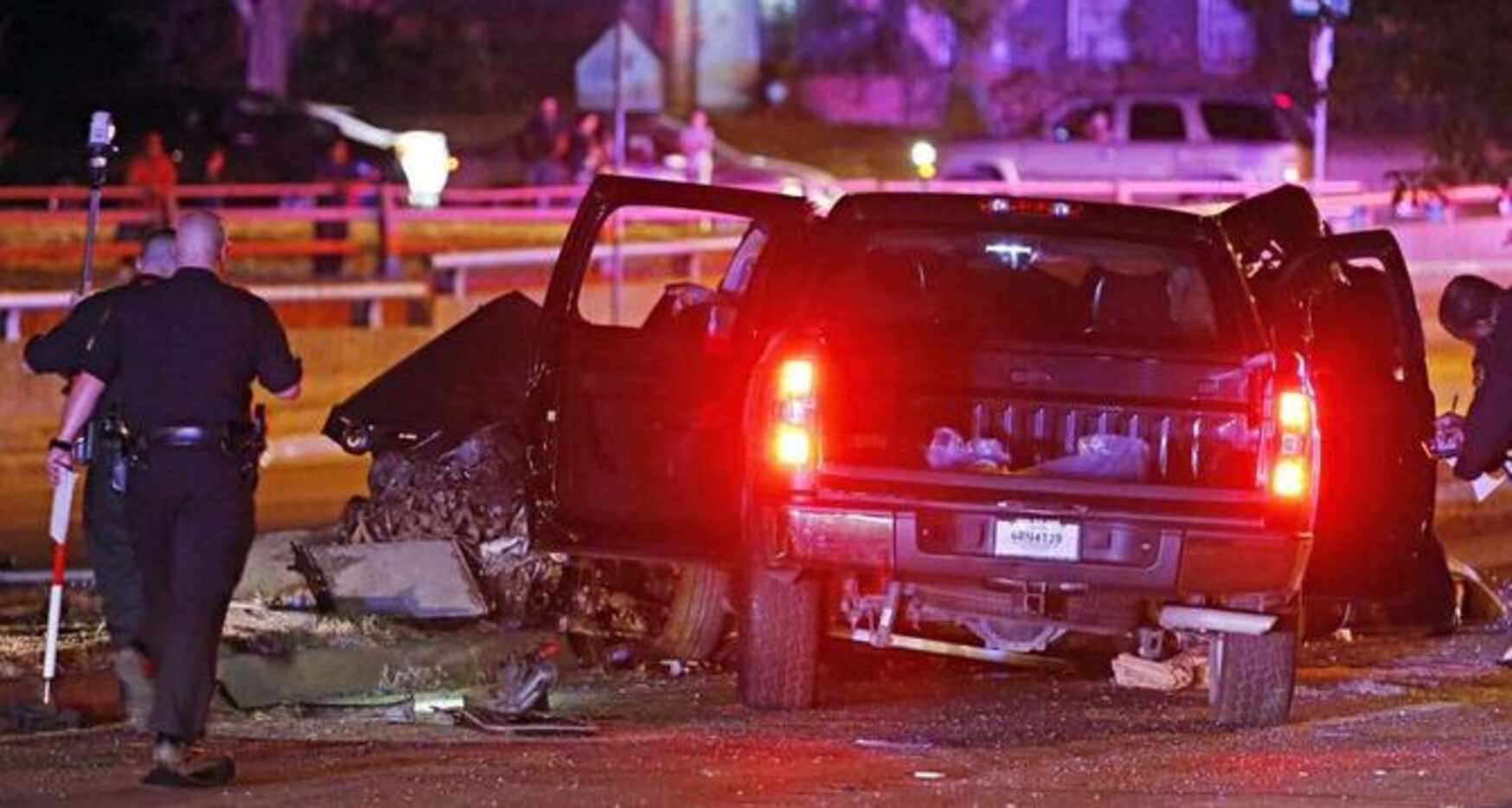 Agentes de la policía de Dallas examinan los restos de uno de los vehículos involucrados en...